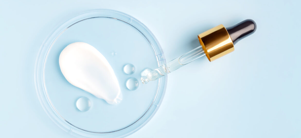 smear of cream stroke and round transparent drop of gel serum in a petri dish on a blue background. Concept laboratory tests and research, making and testing cosmetic